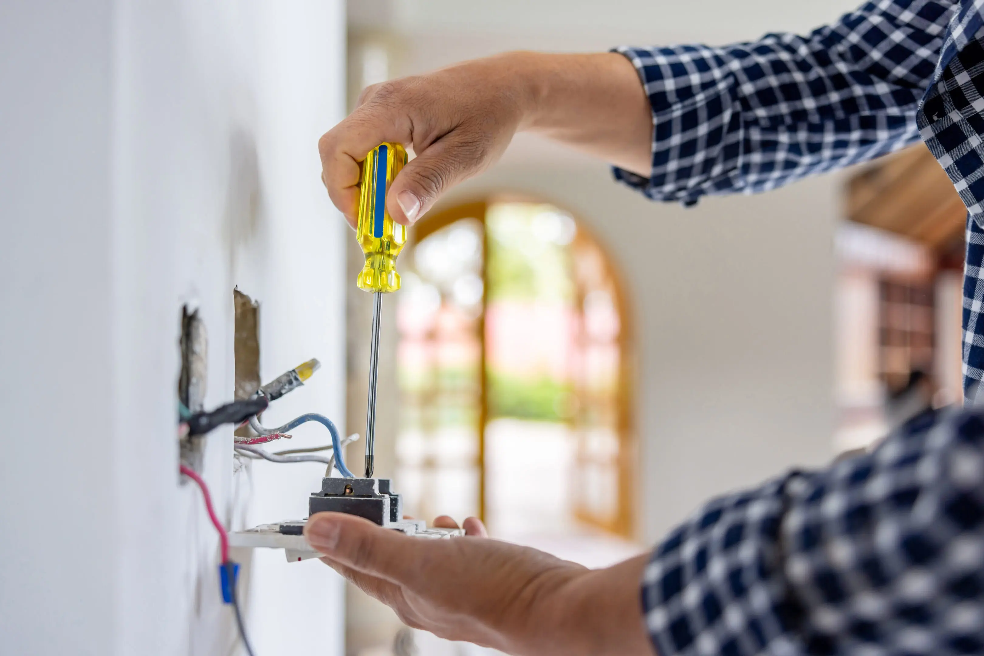 Electrician repairing a wall socket