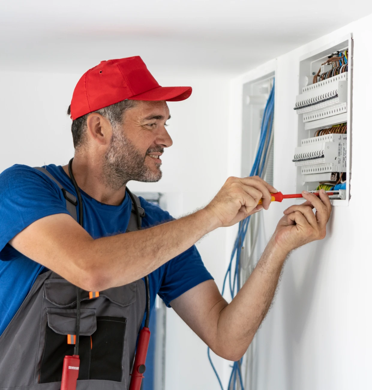Man fixing electrical wiring in wall