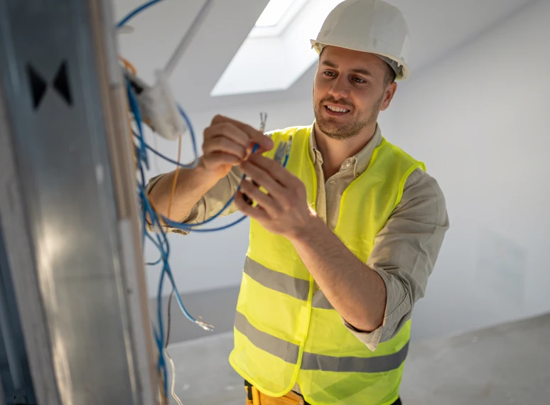 Construction worker fixing electrical wires.