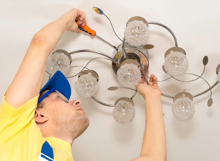 Electrician installing decorative ceiling light