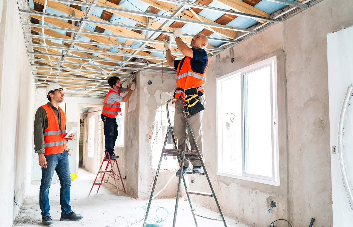 Construction workers installing ceiling framework
