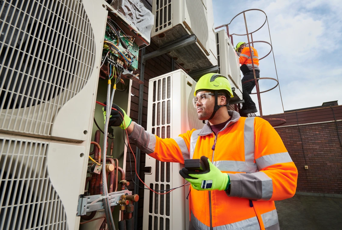 Workers maintaining air conditioning systems